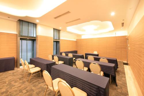 a conference room with tables and chairs and windows at Atsugi Urban Hotel in Atsugi