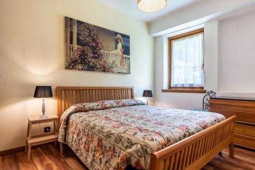 ein Schlafzimmer mit einem Bett und einem Wandgemälde in der Unterkunft Appartamento Dolomiti di Brenta in Pinzolo