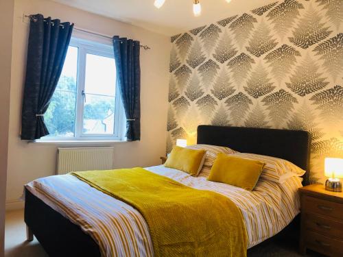 Starfish Cottage في تشارلزتاون: غرفة نوم بسرير مع شراشف صفراء ونافذة