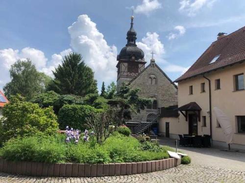 a building with a clock tower in the background at Ferienwohnung im Herzen von Thüringen in Blankenhain