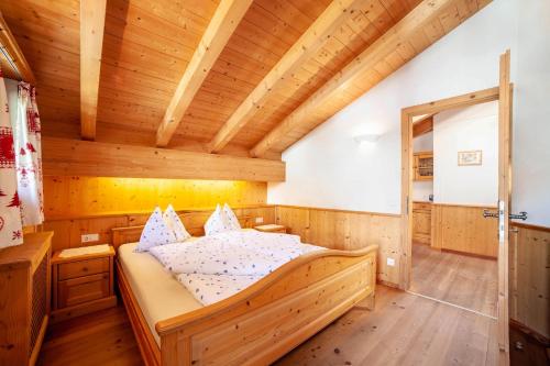 a bedroom with a bed in a wooden house at Hof am Schloss Apartement Lärche in Montechiaro