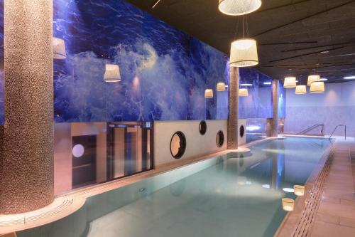 a swimming pool with a mural on the wall at Port Tower by Isrotel Design in Tel Aviv