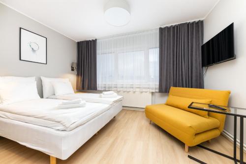 een woonkamer met een bed en een gele stoel bij Reldor Motell in Pärnu