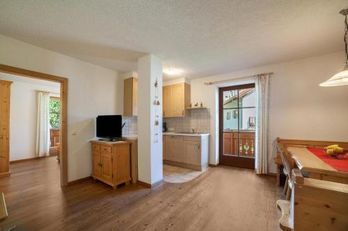 a kitchen with a table and a television in it at Hof am Schloss Apartment Edelweiss in Montechiaro