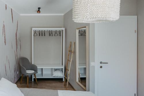 メルビッシュ・アム・ゼーにあるHaus Mörbischの鏡と椅子付きのベッドルーム1室