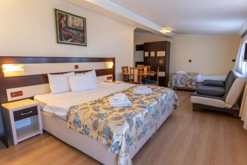 a hotel room with a bed and a chair at Hotel Karacam in Foça