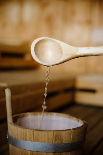 a wooden spoon with water pouring into a wooden bowl at Berghotel Engstligenalp Adelboden in Adelboden