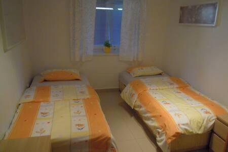 two beds in a small room with a window at Luxury apartment fireplace + sauna in Stará Paka
