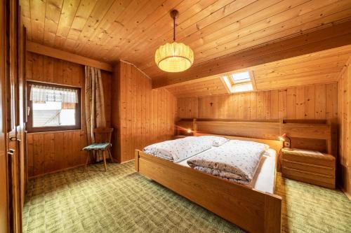 1 dormitorio con 1 cama en una habitación de madera en Rotsteinhof Apartement Bergblick en Verano