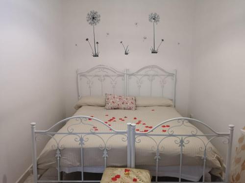 a bedroom with a white bed with flowers on it at Villa Rhaele in Taranto