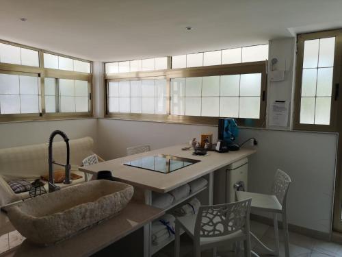 a kitchen with a sink and a counter with windows at villa mina con vasca idromassaggio in Taranto