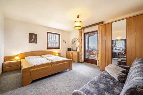 een slaapkamer met 2 bedden en een bank bij Rotsteinhof Apartement Sonnenschein in Verano