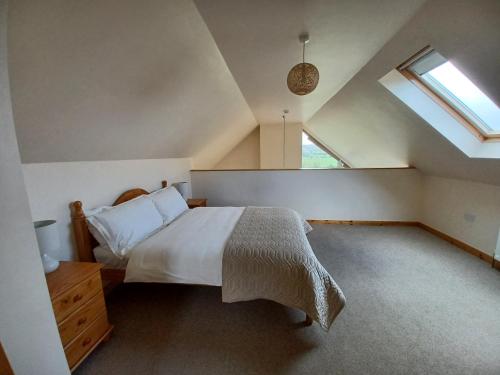 a bedroom with a large bed and a window at The Chalet at Corvally in Portrush
