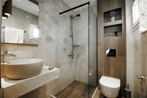 a bathroom with a shower and a sink and a toilet at Akti Liakada Hotel in Gerakini