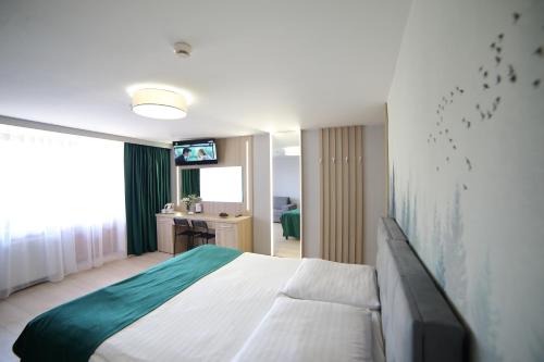 a bedroom with a bed and a desk and a television at Ośrodek Wypoczynkowy Pod Dębem in Wójtowice