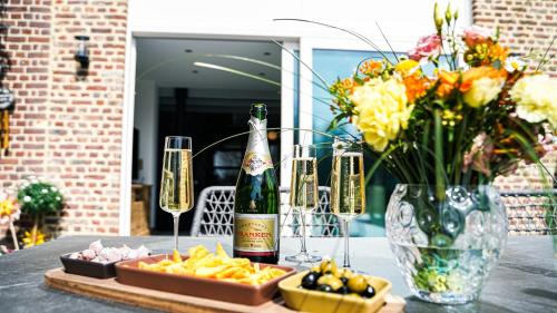 a table with a bottle of champagne and a tray of food at Le Paradis d'Henri in Hannut
