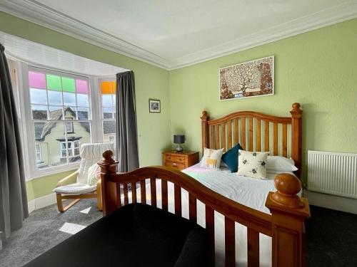 a bedroom with a wooden bed and a window at Bryncelyn Guesthouse in Llanwrtyd Wells