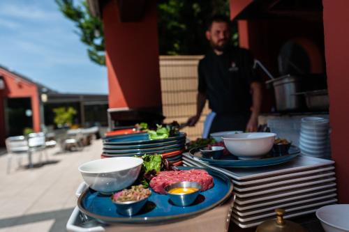 a man standing behind a table with plates of food at Campanile Beaune in Beaune