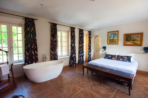 a bedroom with a tub and a bed and a bath tub at Moulin de Fourges in Fourges