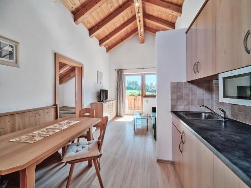 eine Küche mit einem Holztisch und einer Holzdecke in der Unterkunft Berggasthof Bärnstatt in Scheffau am Wilden Kaiser