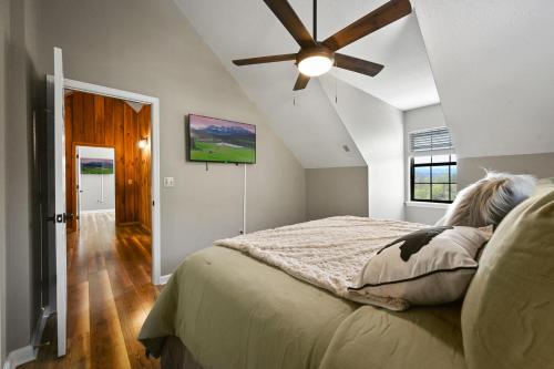 a bedroom with a bed with a ceiling fan at Private Mountain Cabin, hot tub escape in the Smokies, with THE view in Sevierville