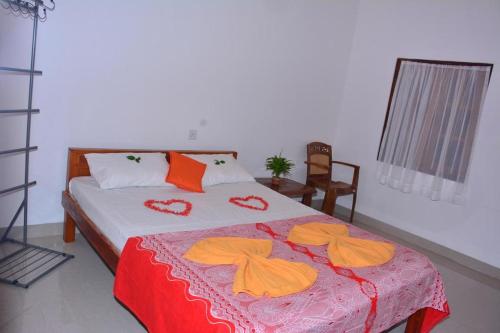 a bedroom with a bed with orange towels on it at Pleasant Park Holiday Inn in Trincomalee