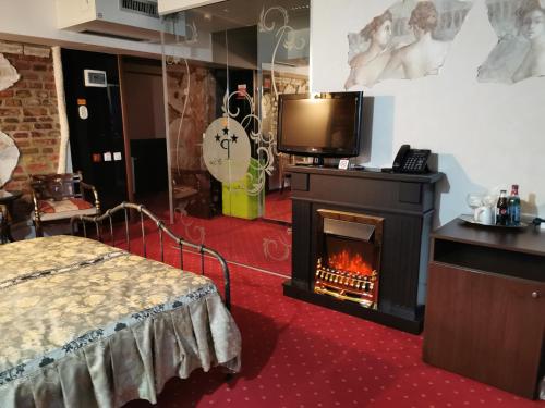 ブカレストにあるGrand Pier Boutique Villaの暖炉、テレビ、ベッドが備わる客室です。