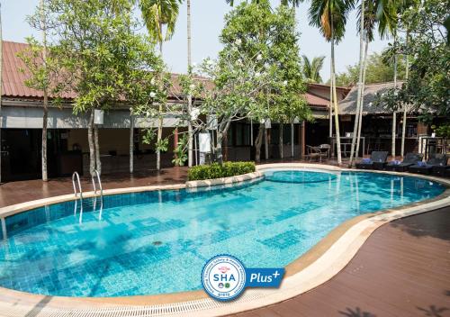 a swimming pool in front of a hotel at Baan Amphawa Resort & Spa - SHA Certified in Amphawa