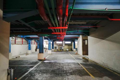 an empty parking garage with blue and red pipes at Empress Hotel Makassar City Center by LIFE in Makassar