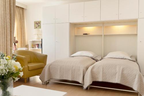 sypialnia z 2 łóżkami i krzesłem w obiekcie Berolina Wohnung 103 w mieście Dahme