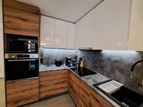 a kitchen with white cabinets and a black counter top at Villa Field6 in Révfülöp