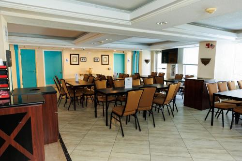 a dining room filled with tables and chairs at Garnet Inn & Suites, Orlando in Orlando