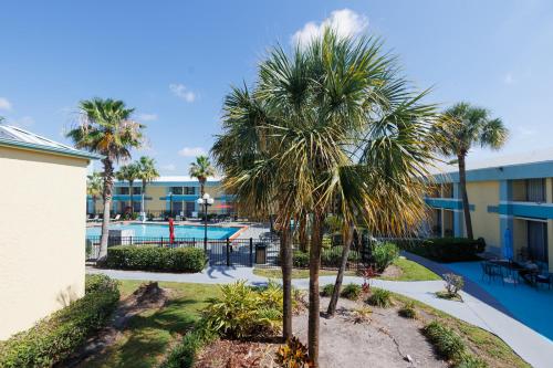 a courtyard with palm trees and a swimming pool at Garnet Inn & Suites, Orlando in Orlando