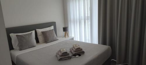 a bedroom with a bed with two pairs of shoes on it at Olhar Sobre o Alva - Turismo Rural e Sabores in São Sebastião da Feira