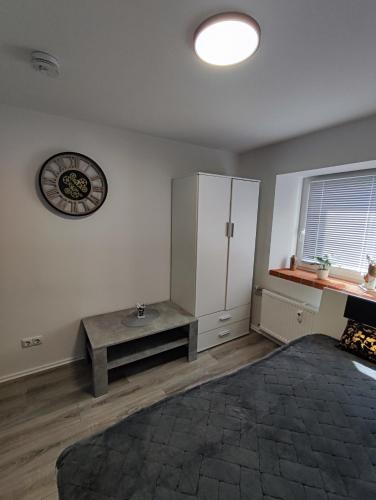 sala de estar con mesa y reloj en la pared en Wunderschöne Ferienwohnung en Lengfurt