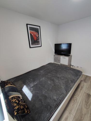 a bed in a room with a flat screen tv at Wunderschöne Ferienwohnung in Lengfurt