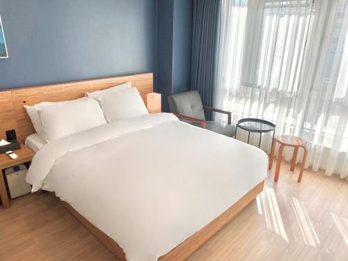 ein Schlafzimmer mit einem großen weißen Bett in einem Zimmer in der Unterkunft Chungchoho Best Hotel in Sokcho