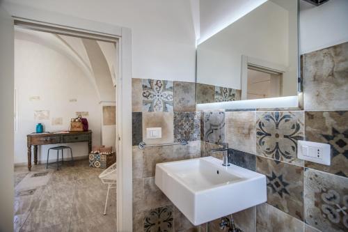 un bagno con lavandino e specchio di Il Nido - Le Case di Valentina a Gallipoli