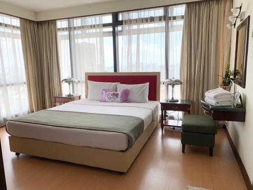 ein Schlafzimmer mit einem großen Bett mit zwei lila Kissen in der Unterkunft Universal Times Suites At Times Square in Kuala Lumpur