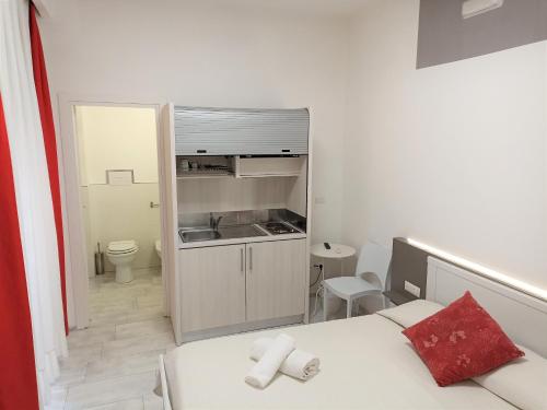 a small bedroom with a bed and a kitchen at Be Inn in Salerno
