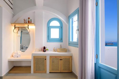 a bathroom with a sink and a mirror at Kalestesia Suites in Akrotiri