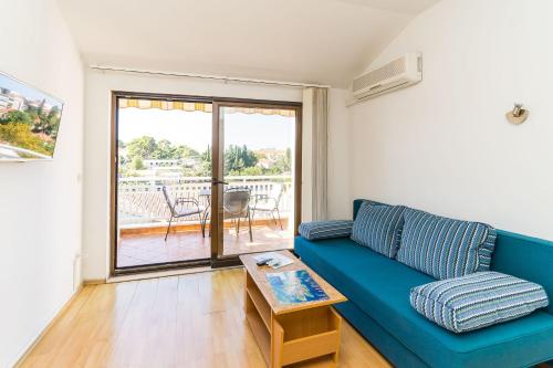 a living room with a blue couch and a table at Apartments Princ Hrvoje in Dubrovnik