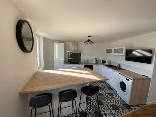 a kitchen with a counter and stools in a room at Coeur de ville , 70m2 , 2 chambres in Saint-Brieuc