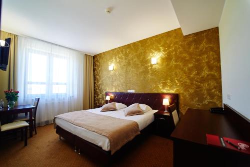 Habitación de hotel con cama grande y escritorio. en Hotel Szyszko, en Suwałki