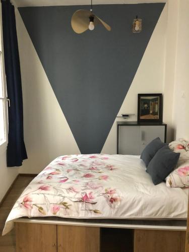 - une chambre avec un grand lit fleuri dans l'établissement Quartier d'Emily in Paris, à Paris