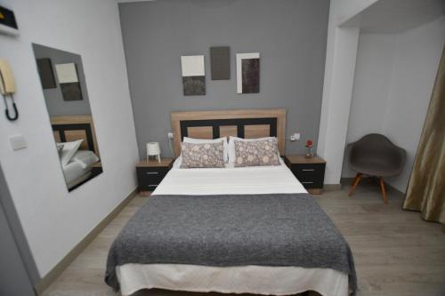 a bedroom with a bed and a chair and a mirror at HB Torrevieja in Torrevieja