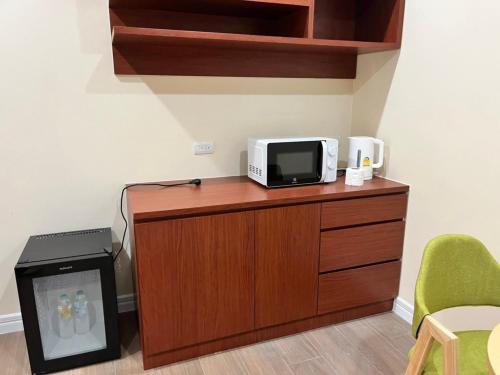 a microwave sitting on top of a wooden counter next to a room at Anwari Hotel in Bangkok