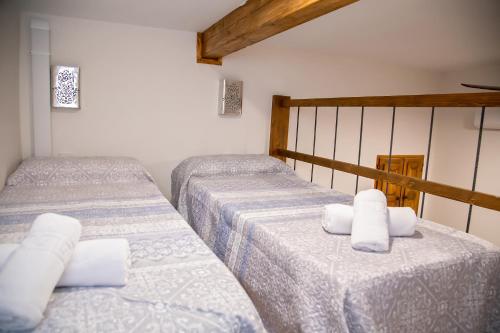 two twin beds in a room with white sheets at LA CASA MORISCA in Alicante