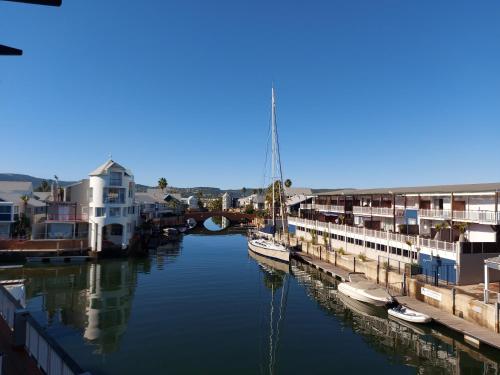 a group of boats docked in a river with buildings at Belle View @ Knysna Quays in Knysna