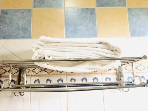 einen Handtuchhalter mit Handtüchern im Bad in der Unterkunft KAMAO Hotel in Arusha